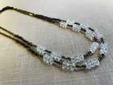 top view of gemstone bead necklace comprising clear natural quartz, golden pyrite and dark bronze.