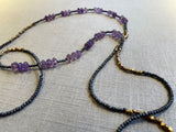 closeup view of gemstone bead necklace comprising purple amethyst, grey pyrite and bronze.