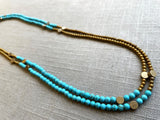 top view of gemstone bead necklace comprising turquoise, gold hematite and bronze dot accents.