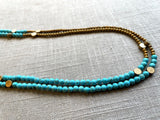 side view of gemstone bead necklace comprising turquoise, gold hematite and bronze dot accents.