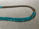 side view of gemstone bead necklace comprising aqua quartz, gold hematite and bronze hex accents.