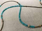 closeup view of gemstone bead necklace comprising aqua quartz, gold hematite and bronze hex accents.