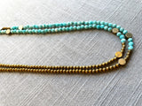 side view of gemstone bead necklace comprising aqua amazonite, gold hematite and bronze dot accents.