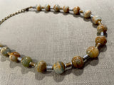 top view of gemstone bead necklace comprising blue/brown calcite, gold and silver hematite.