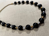 top view of gemstone bead necklace comprising black onyx, gold and silver hematite.