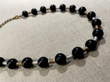 side view of gemstone bead necklace comprising black onyx, gold and silver hematite.
