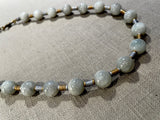 side view of gemstone bead necklace comprising white siberian moonstone and gold and silver hematite.