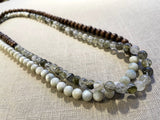 top view of gemstone bead necklace comprising green tourmaline, white siberian moonstone and brown exotic wood.