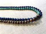 side view of gemstone bead necklace comprising blue lapis, green amazonite and brown exotic wood.