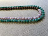 side view of gemstone bead necklace comprising light purple kuznite, green amazonite and brown exotic wood.