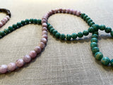 closeup view of gemstone bead necklace comprising light purple kuznite, green amazonite and brown exotic wood.