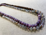 top view of gemstone bead necklace comprising purple lepidiolite, green flourite and brown exotic wood.