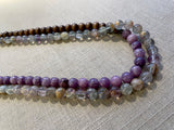 side view of gemstone bead necklace comprising purple lepidiolite, green flourite and brown exotic wood.