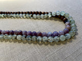 side view of gemstone bead necklace comprising purple lepidiolite, green prehnite and brown exotic wood.