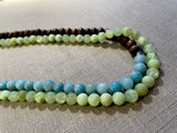 side view of gemstone bead necklace comprising blue larimar, green calcite and brown exotic wood.