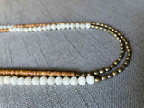 side view of gemstone bead necklace comprising golden feldspar, off-white siberian moonstone and light gold hematite