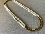 top view of gemstone bead necklace comprising white moonstone , off-white fossil jasper and gold hematite
