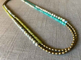 top view of gemstone bead necklace comprising white k2 granite, green jade, blue amazonite and light gold hematite