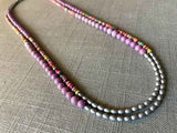 top view of gemstone bead necklace comprising multicolored vinyl discs, light purple phosphosiderite and silver hematite