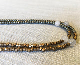 side view of gemstone bead necklace comprising white moonstone and metallics