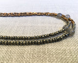 side view of gemstone bead necklace comprising grey moonstone and metallics