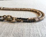 side view of gemstone bead necklace comprising taupe quartz, beige shell and sterling silver mariners link