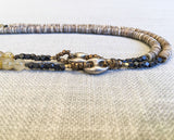 side view of gemstone bead necklace comprising rutilated quartz, beige shell and sterling silver mariners link