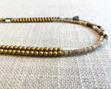 side view of gemstone bead necklace comprising neutral shell and matte gold