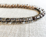 side view of gemstone bead necklace comprising neutral shadow quartz, dark grey pyrite and taupe quartz