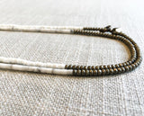 side view of gemstone bead necklace comprising white shell and matte light gold