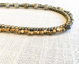 side view of gemstone bead necklace comprising green labradorite, neutral shell and metallics