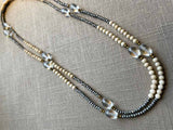top view of gemstone bead necklace comprising clear rock quartz, beige fossil jasper and metallics