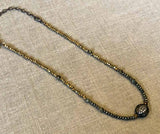 top view of pave evil eye pendant hung on metallic bead choker