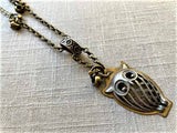 closeup of antique owl pendant on chain mix