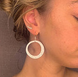 model wearing organic-shaped silver earrings