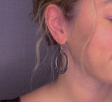 model wearing organic-shaped silver earrings