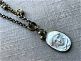 closeup of antique carved Medusa cameo pendant on chain mix