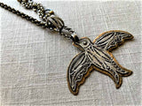 closeup of antique filigree bird pendant on chain mix