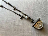 closeup of antique salt shaker birdhouse pendant on chain mix