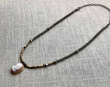 top view of antique cameo pendant hung on metallic bead choker