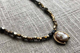 closeup of antique cameo pendant hung on metallic bead choker