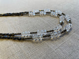 side view of gemstone bead necklace comprising clear natural quartz, golden pyrite and dark bronze.