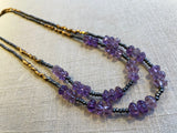 top view of gemstone bead necklace comprising purple amethyst, grey pyrite and bronze.