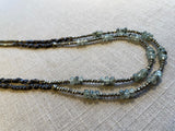 side view of gemstone bead necklace comprising green prehnite, golden pyrite and dark bronze. 