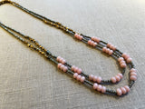 top view of gemstone bead necklace comprising pink opal, grey pyrite and bronze. 