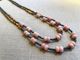 top view of gemstone bead necklace comprising pink opal, pyrite and bronze. 