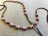 closeup view of gemstone bead necklace comprising pink opal, grey pyrite and bronze. 