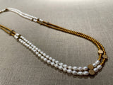 top view of gemstone bead necklace comprising white pearl, gold and silver hematite and bronze dot accents. 