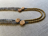 side top view of gemstone bead necklace comprising antique hand-carved bone flowers, grey moonstone and gold hematite