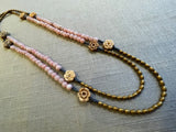  top view of gemstone bead necklace comprising antique hand-carved bone flowers, pink opal and gold hematite